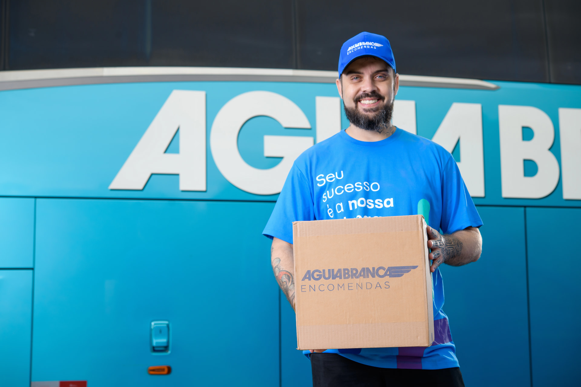 Homem segurando uma caixa com o logo da Águia Branca Encomendas